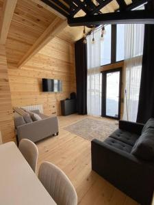 a living room with a couch and a table at Gudauri Deka Alpine Cottages in Gudauri