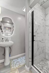 a white bathroom with a sink and a shower at Boutique Studio Hideaway Near Forest Park in Saint Louis