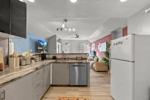 a kitchen with white cabinets and a white refrigerator at Boutique Studio Hideaway Near Forest Park in Saint Louis