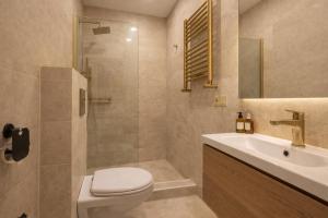 a bathroom with a toilet and a sink at City Heart Apartment in Tbilisi City +4 photos