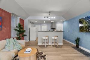 a living room with a couch and a kitchen at Boutique Studio Hideaway Near Forest Park in Saint Louis +26 photos