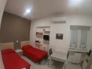 a living room with a red couch and a table at B&B Ostello Villafranca in Pignola
