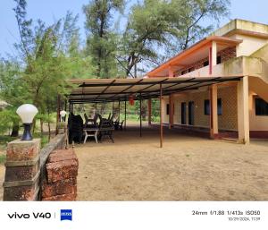a patio with tables and chairs in front of a house at Silver sand beach resort in Malvan