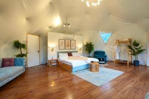 a bedroom with a bed and a couch in a room at The GlampView Resort in Manāli