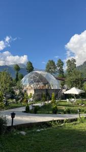a building with a glass dome in a park at The GlampView Resort in Manāli