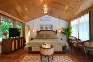 a bedroom with a bed and a flat screen tv at The GlampView Resort in Manāli