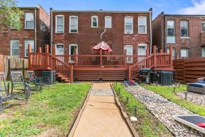 a backyard with a large deck and a grill at Abstract Haven | Stylish 1BR by Tower Grove in Saint Louis
