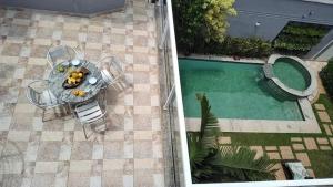 an overhead view of a table and chairs next to a pool at Casa de temporada com piscina in Peruíbe
