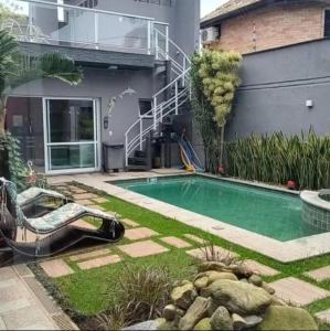 a swimming pool in the yard of a house at Casa de temporada com piscina in Peruíbe