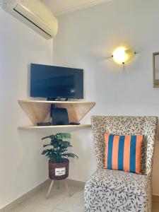 a living room with a chair and a flat screen tv at Bayview Apartment 106 in Albufeira
