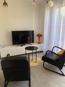 a living room with a couch and a table and chairs at Le logis de Niort Appart Hôtel Le bis in Niort
