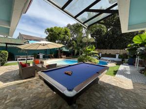 a pool table in front of a swimming pool at The Barkly House Staycation in Biñan