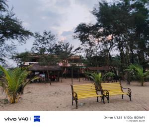 a yellow park bench in front of a resort at Silver sand beach resort in Malvan
