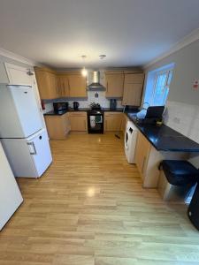 a kitchen with wooden floors and a white refrigerator at Cosy room 6 T Gatwick in Crawley