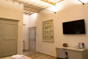 a living room with a television on a wall at San Giacomo Suites in Città di Castello