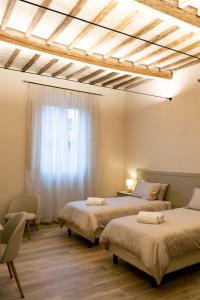 a bedroom with two beds and a window at San Giacomo Suites in Città di Castello