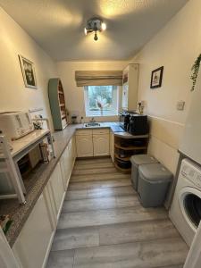 a kitchen with a sink and a washing machine at Town Centre Apartment in Mold