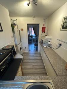 a kitchen with a staircase leading to a living room at Town Centre Apartment in Mold