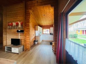 a living room of a log cabin with a kitchen at The Nordic Retreat in Gramsbergen