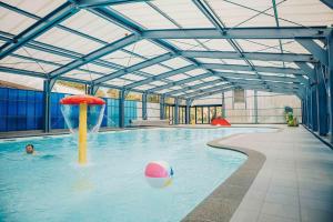 a pool with a ball and an umbrella in the water at The Nordic Retreat in Gramsbergen