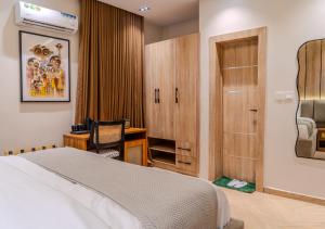 a bedroom with a bed and a desk and a chair at Rooks Rest Inn & Apartments in Lagos