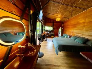 a bedroom with a bed and a mirror in a room at Cabaña Río San Carlos Ecolodge in Boca Tapada