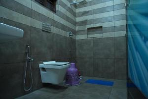 a bathroom with a purple toilet and a shower at pathayil villa in Thekkady +15 photos