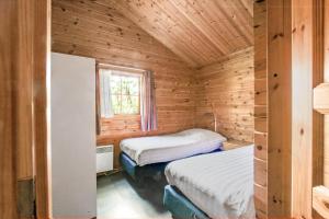a bedroom with two beds in a wooden cabin at The Nordic Retreat in Gramsbergen +12 photos