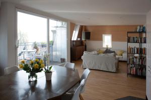 a living room with a table with flowers on it at City centre with lake view in Neuchâtel