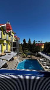 a swimming pool in front of a building with chairs at DeltaHotel in Ureki