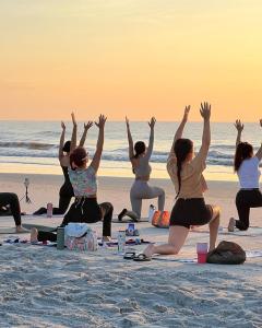 a group of women doing yoga on the beach at Seawind in Kannur