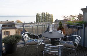 a table and chairs on a balcony with a view of the water at City centre with lake view in Neuchâtel
