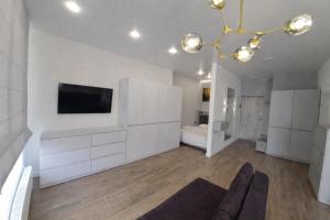 a living room with a tv and a couch at ApartPlus - Затишні апартаменти in Dnipro