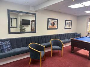 a living room with a couch and a pool table at Silversands Hotel in Blackpool