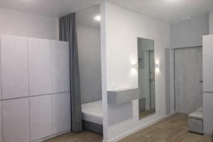 a white room with a bed and a mirror at ApartPlus - Затишні апартаменти in Dnipro +11 photos