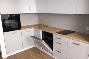 a kitchen with white cabinets and a sink and a stove at ApartPlus - Затишні апартаменти in Dnipro