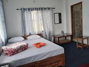 a bedroom with a bed with an orange robe on it at Pinepeak in Lava +4 photos