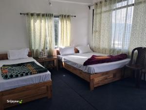 two beds sitting in a room with windows at Pinepeak in Lava