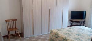 a bedroom with a bed and a tv and a chair at la casa di Titty con wi fi in Avellino