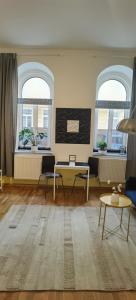 ein Wohnzimmer mit einem Tisch und zwei Fenstern in der Unterkunft Amarilis - Dolce Duo Homes in Wien