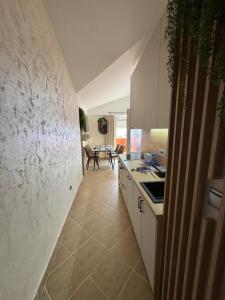 a kitchen with white cabinets and a tile floor at Apartman Sunce in Budva +8 photos