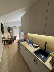 a kitchen with a sink and a dining room at Apartman Sunce in Budva