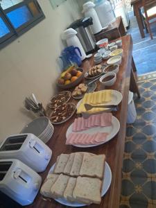 a long table with bread and other food on it at Le Vrero Boutique Hotel in Colonia del Sacramento