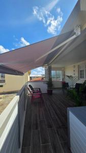 a patio with awning and chairs on a deck at Villa Maxime in Sainte-Marie