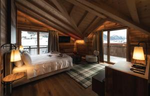 a bedroom with a bed in a room with windows at Mont Chalet Nevada - Hotel & Spa in Livigno +100 photos