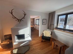 a living room with a fireplace and a room with a table at Tilli´s Garten in Scharnitz