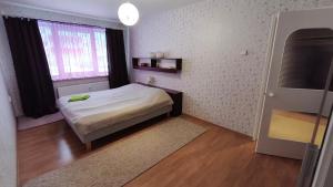a small bedroom with a bed and a window at Vilde Apartment in Tallinn