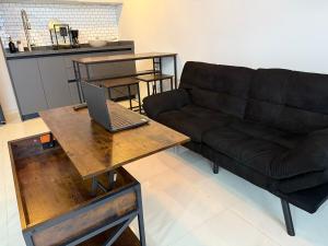 a living room with a couch and a laptop on a table at Apartment with pool on Paseo Santa Lucia in Monterrey