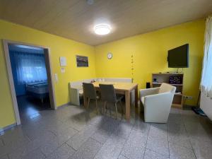a dining room with yellow walls and a table and chairs at Gästehaus Durst in Rust