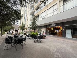 a group of tables and chairs in front of a building at Apartment with pool on Paseo Santa Lucia in Monterrey